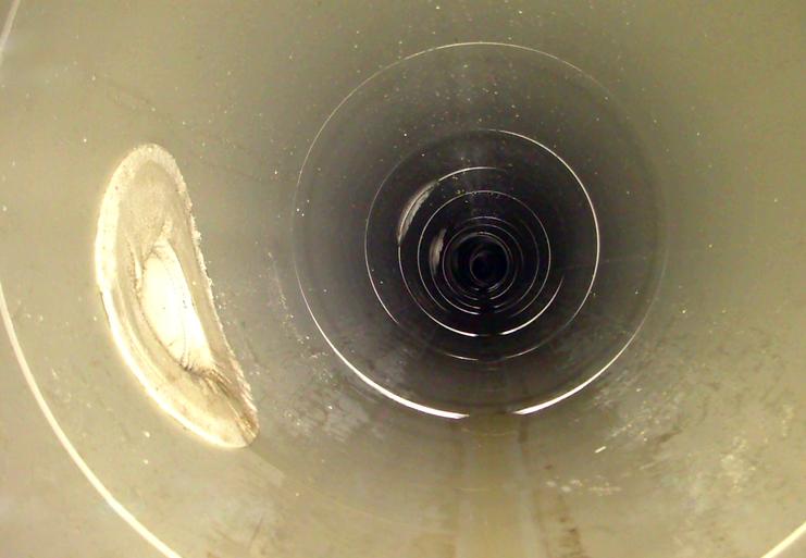 Blick in ein leeres, zylindrisches Rohr mit glatten Innenwänden und einem dunklen Ende.