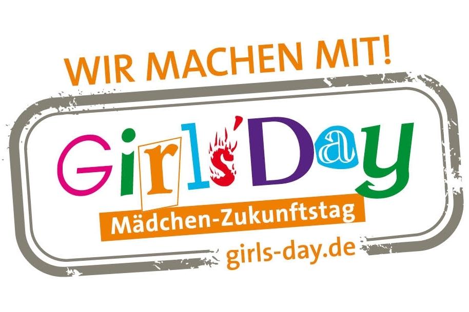 Logo für den Girls' Day mit dem Text „Wir machen mit!“, umgeben von bunten Buchstaben und einem orangefarbenen Banner.