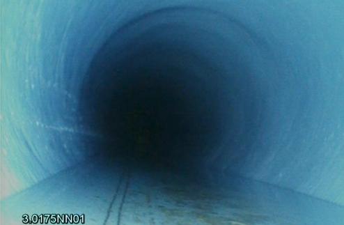 Blick in einen langen, dunklen Rohrabschnitt mit sichtbarem, glattem inneren Verlauf. Farbton ist überwiegend blau.