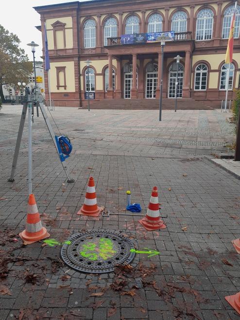 Blick auf das Gebäude "Saalbau" mit Baustellenabsperrung und vermessungstechnischer Ausrüstung in der Vordergrund.