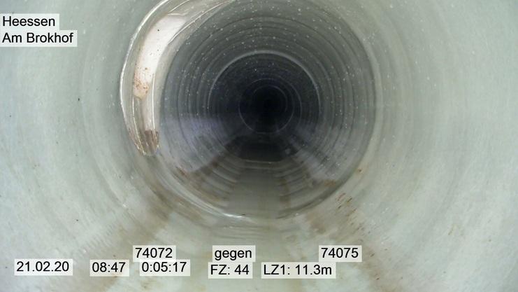 Innenansicht eines Rohres mit glattem, hellem Innenraum und dunklem Ende. Hinweisstücke sind unten aufgeführt.