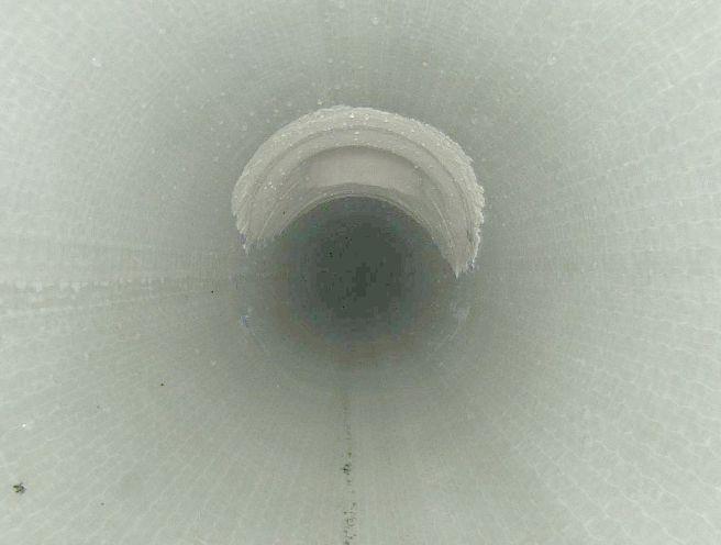 Blick in ein hohes, zylindrisches Rohr mit glatten Wänden und dunklem Inneren.