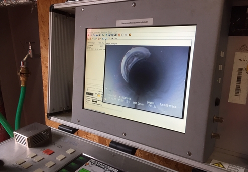 Monitor zeigt eine Kameraansicht des Inneren eines Rohres mit digitalen Messwerten und Steuerungstasten.